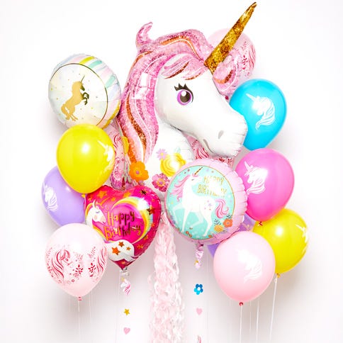 A bouquet of colourful unicorn balloons on a white background, the feature balloon in the middle is a large unicorn head balloon with a gold horn and pink mane.