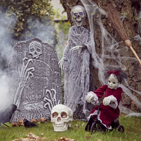 outdoor halloween decorations with tombstones, skeletons and spider webs