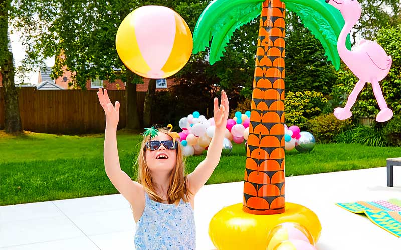 Young girl playing with beach ball in the garden